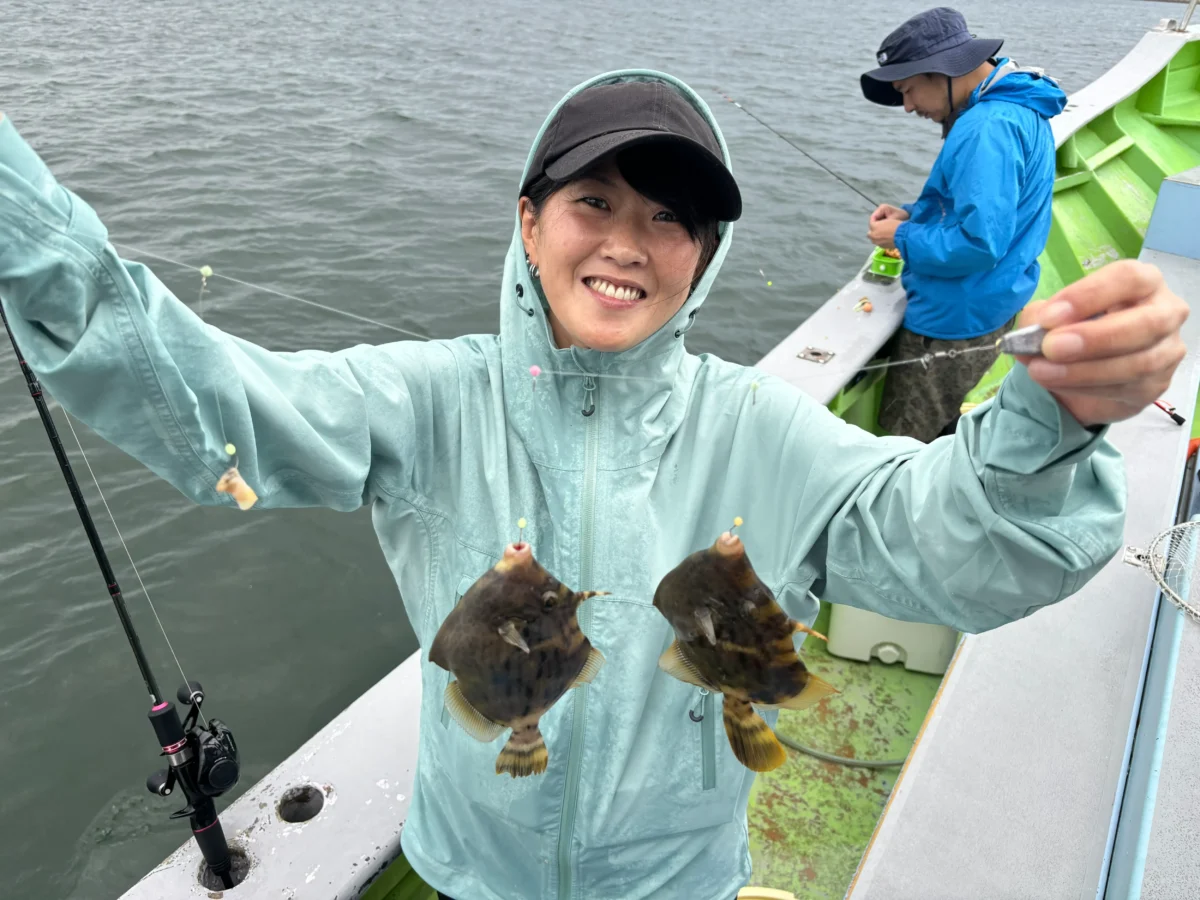 おざき丸のカワハギ釣りで良型をダブルヒットさせて笑顔の女性のお客様