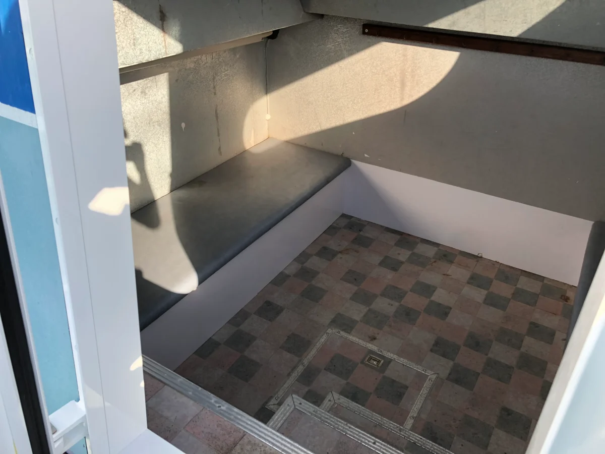 エアコン完備で移動中や荒天時も快適に休める、おざき丸の広々としたキャビン内部